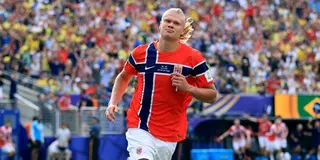 Erling Haaland of Norway runs and celebrates during the 2026 World Cup. A player from Brazil lays on the grass in the background.