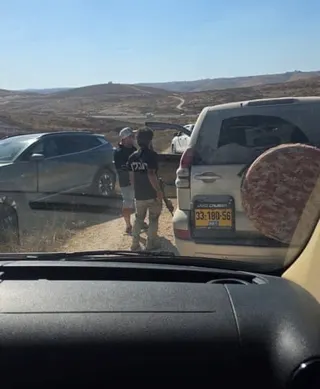 Armed men block a vehicle.
