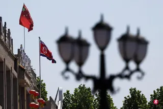 中朝国旗在朝鲜驻沈阳总领馆驻丹东领事办公室外随风飘扬，摄于6月8日。 （路透社）