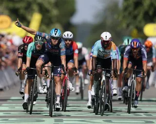 Tim Merlier raises his arm in celebration as he wins stage eight of the Tour de France