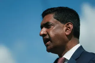 A man in a suit under a blue sky.