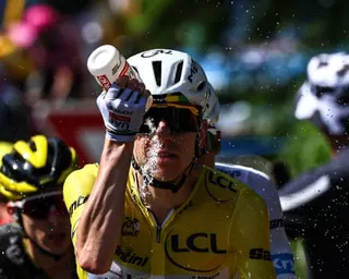Tadej Pogacar tries to cool himself down with water