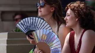 Two young women holding fans
