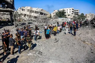 People gather by the rubble of destroyed buildings following an Israeli strike on an industrial area in Gaza City on July 12, 2026.