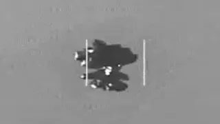 An object which is thought to be an Unidentified Anomalous Phenomena in the center of the frame. The image is in black and white and is grainy.