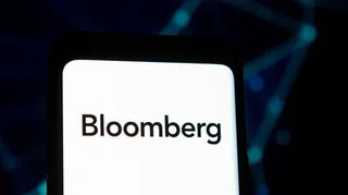 The Bloomberg logo on a phone screen against a black backgound