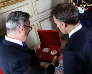 Keir Starmer inspects his medal with Macron
