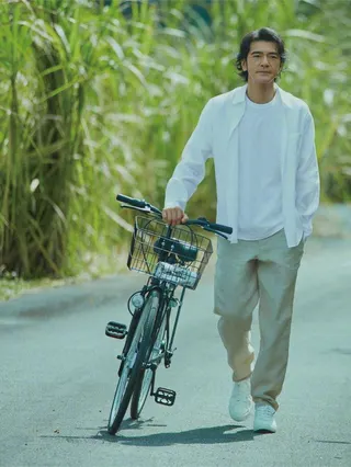 金城武悠閒的走在鄉間小路，帥氣依舊。(取材自微博)