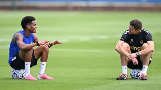 Xabi Alonso talking to Estevao Willian while both are sat on balls