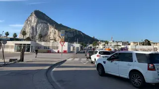 從西班牙駛往直布羅陀的汽車正在排隊等候通關，背景可見直布羅陀岩石