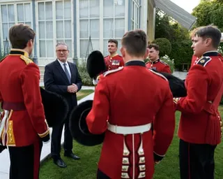 Keir Starmer meets members of the Grenadier guards who are wearing red uniforms