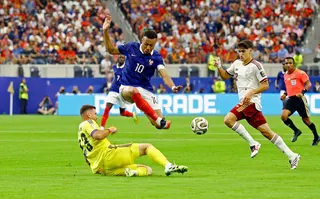 France's Kylian Mbappé is beaten to the ball by Spain keeper Unai Simon.