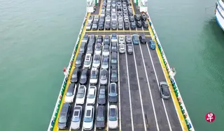 在中国海南省海口市秀英港，新能源汽车驶入“绿源二号”新能源汽车专用运输船准备过海，此图摄于1月30日。 （新华社）