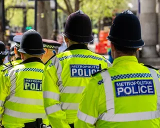 Several Metropolitan police offers in hi-vis seen from behind