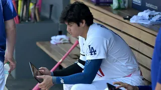 Shohei Ohtani checks an iPad in the Dodgers dugout.