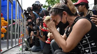 A woman prays for her deceased daughter and her son-in-law Suwitcha Sirililung in front of the Rong Beer Na Lat Phrao bar in Bangkok on July 14, 2026.