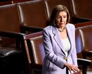 a woman in a light purple suit stands next to rows of seats
