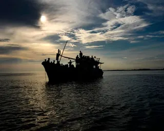 silhouette of a boat carrying rohingya
