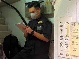 A policeman stands at the entrance to the Have A Nice Stay independent bookstore after the officers raided the premises and arrested employees in Hong Kong on Wednesday.