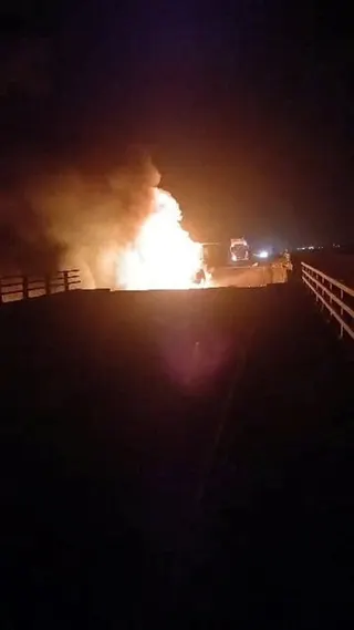 A fire burns on the damaged bridge.