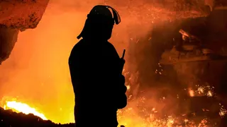 A silhouette of a steel worker