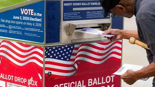 A man dropping a ballot in the mail box