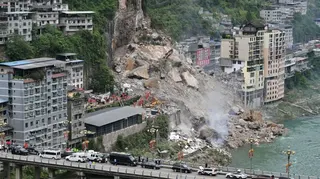 Wide view of a landslide on a hillside in Chongqing, China, seen from a distance.