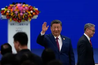 習近平舉手找招呼，背景是藍色底