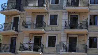 A resident stands on a balcony of an apartment building damaged by a Russian missile strike, amid Russia's attack on Ukraine, in Odesa, Ukraine. Ph July 15, 2026.