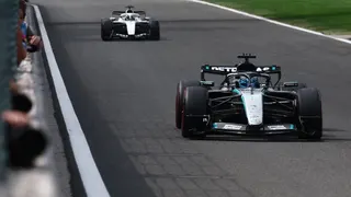 George Russell driving the Mercedes during Belgian Grand Prix qualifying with a Cadillac in the background