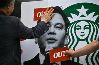Activists put stickers on the image of Shinsegae Chairman Chung Yong-jin during a rally calling for a boycott of the Starbucks coffee chain in Seoul May 27, 2026. — AFP pic