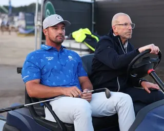 Bryson DeChambeau is driven by a rules official to the scene of the penalty
