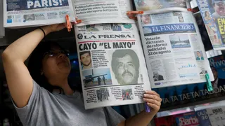 A newspaper seller arranges newspapers reporting the El Paso, Texas, U.S., arrest of Mexican drug lord Ismael "El Mayo" Zambada