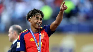 Spain's Lamine Yamal celebrates after winning the World Cup. He is pointing up and smiling