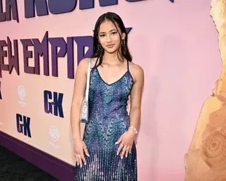 a girl in a dress poses at a movie premiere