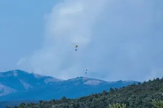 Smoke is seen as firefighter helicopters battle a huge wildfire north of Madrid that has devastated 29,000 hectares in the Guadalajar province, as seen from Tamajon, north of Madrid on July 21, 2026. (Photo by Pierre-Philippe MARCOU / AFP)
