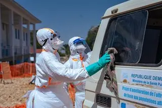 在刚果民主共和国的一次埃博拉疫情应对行动中，世界卫生组织医护人员身穿防护服清洁车辆。