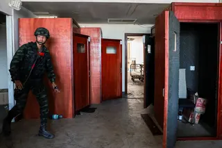 A Thai soldier walks near small booths lined with acoustic foam used to make scam calls inside a compound in Cambodia’s O’Smach border town on February 2. Photo: Reuters