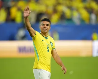 Casemiro in a yellow Brazil jersey waves to the crowd on a pitch
