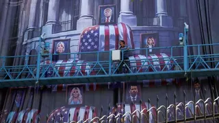 An Iranian worker adjusts an anti-US billboard featuring pictures of US President Donald Trump and his family on top of US flag-draped coffins, in Tehran, Iran, on 16 July 2026