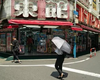 person shades under an umbrella in japan on hot day