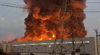 A fire ball rises above a low, light-coloured building.