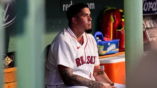 Eduardo Rivera sits in the dugout after being pulled from the game in the first inning.