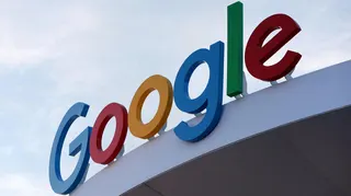 Google's primary-colored logo outside of a building.