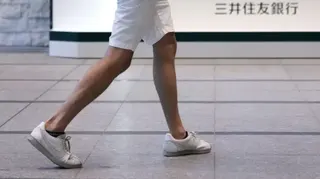 日本東京三井住友銀行某分行門前，一名身穿白色短褲與白色運動鞋，小腿長滿體毛的男子走過（資料圖片）