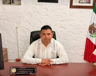 Valentín Lavín Romero sat behind a desk with a flag of Mexico in the background