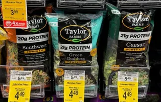 packages of salad greens on a store shelf