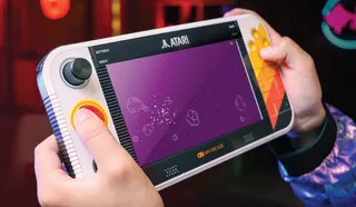 Atari handheld appears in someone's hands.