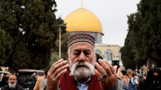 Muslim man prays outside the Dome of the Rock at the start of Ramadan 2025