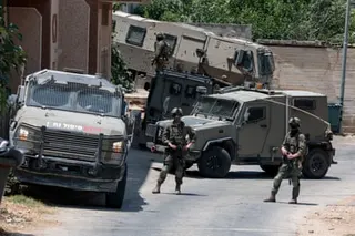 Israeli soldiers by their armoured vehicles
